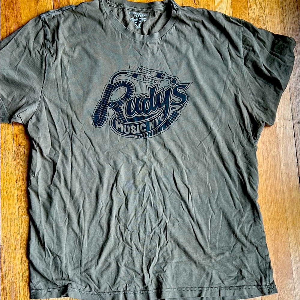 Rudy’s Music men’s tshirt. Khaki with Rudy’s music logo. Size XL